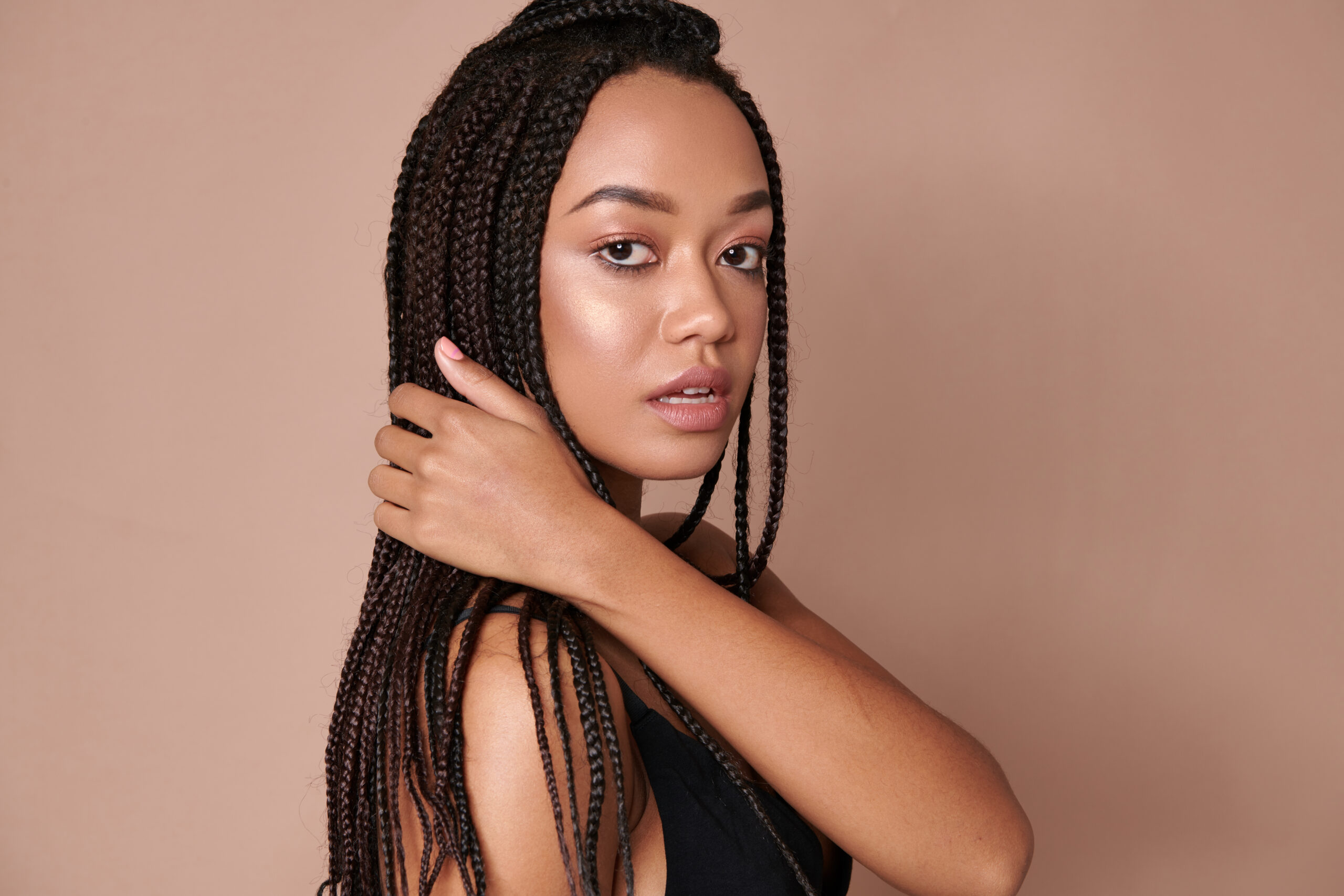 Woman with braids resting her head on her arms
